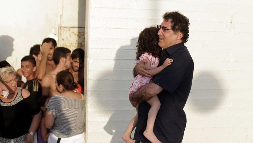 Un Israélien porte un enfant à l'abri sur la plage de Tel-Aviv lors d'une attaque de roquettes le 8 juillet 2014