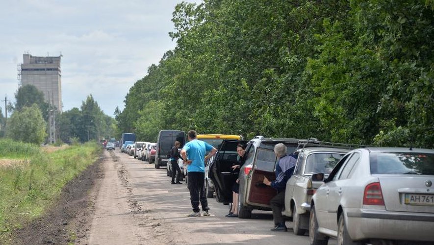 Des habitants de Slaviansk attendent avec leurs véhicules de rentrer chez eux, le 8 juillet 2014 en Ukraine
