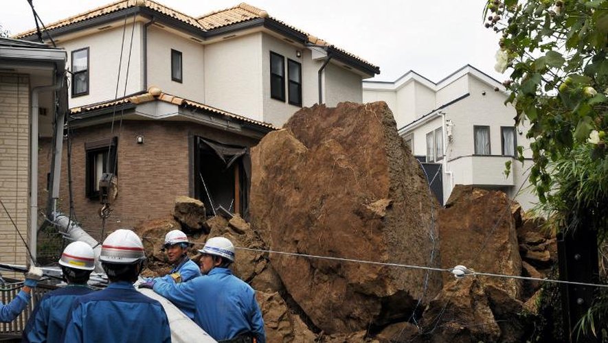 Une maison et un poteau électrique endommagés par une chute de pierres lors du passage du typhon Wipha, le 16 octobre 2013 à Kamakura, dans la banlieue de Tokyo