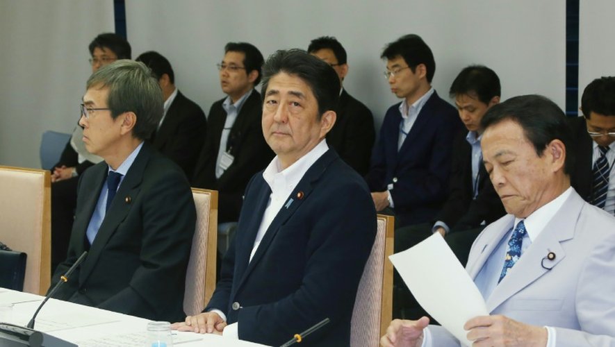 Le Premier ministre japonais Shinzo Abe (C), et le ministre des Finances Taro Aso (D) lors d'une réunion le 24 juin 2016 à Tokyo