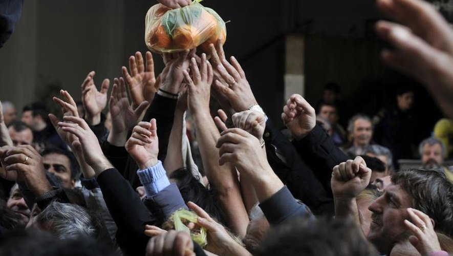 Des Grecs reçoivent des fruits et légumes lors d'une manifestation d'agriculteurs, à Athènes le 6 février 2013