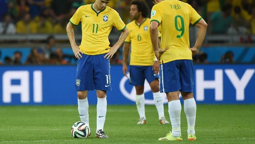 Les Brésiliens Oscar et Fred, têtes basses, après l'un des 7 buts allemands, le 8 juillet 2014 à Belo Horizonte