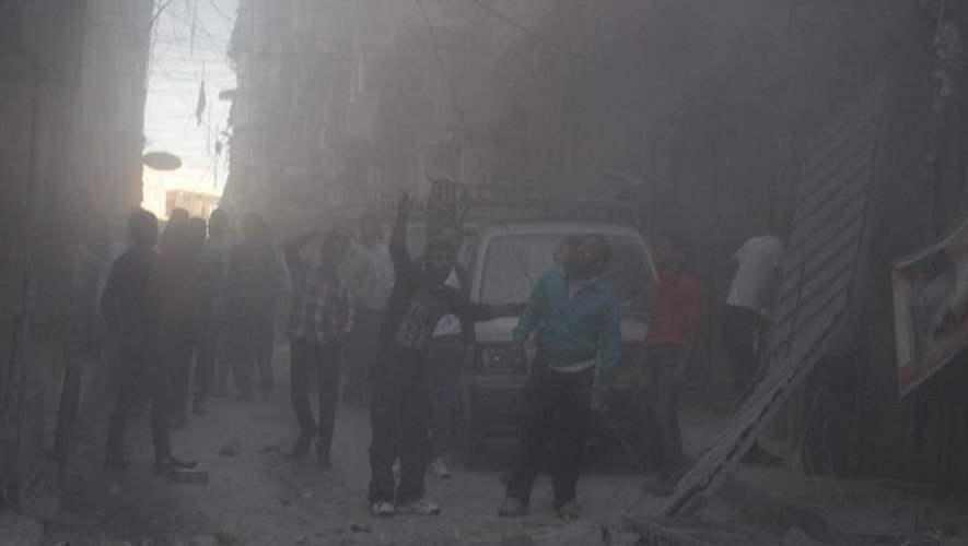 Des Syriens rassemblés dans une rue après un bombardement de l'armée dans le quartier de Bustan al-Qasr, à Alep, le 15 octobre 2013