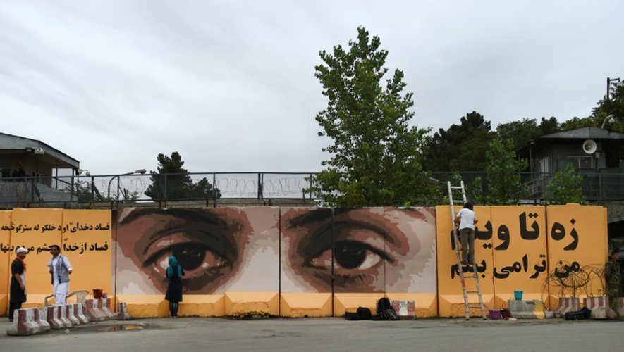 Des yeux et des messages peints par des artistes sur un mur de protection du palais présidentiel de Kaboul pour dénoncer la corruption dans son pays, le 21 juillet 2015