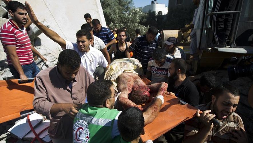 Le corps d'un homme retiré de gravas après un bombardement israélien sur le camp de réfugiés de  Maghazi dans la bande de Gaza, est transporté, le 9 juillet 2014