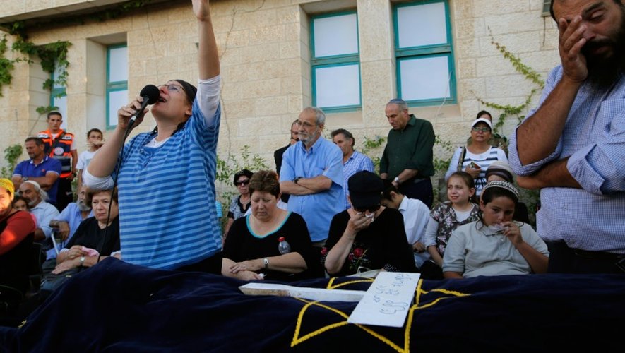 Une mère israélienne prient sur le cercueil de sa fille de 13 ans poignardée dans son sommeil le matin-même par un Palestinien, le 30 juin 2016 dans la colonie de Kiryat Arba en Cisjordanie occupée