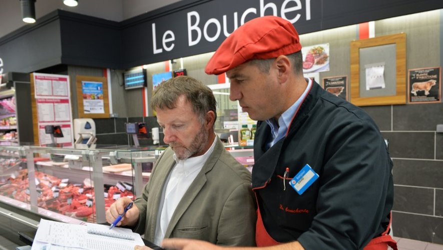 Le chef de service de la DGCCRF, Thierry Laitot, inspecte la viande avec le chef boucher David Jousset, dans le supermarché "Super U" de Neuville-aux-Bois, le 12 août 2015