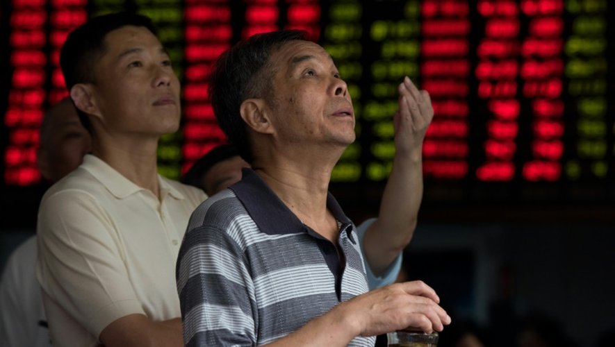 Des investisseurs surveillent les mouvements boursiers le 13 août 2015 chez un courtier de la Bourse de Shanghai