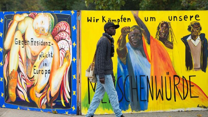 Un réfugié africain marche devant l'entrée du camp de réfugiés de Kreuzberg, à Berlin, le 16 octobre 2013