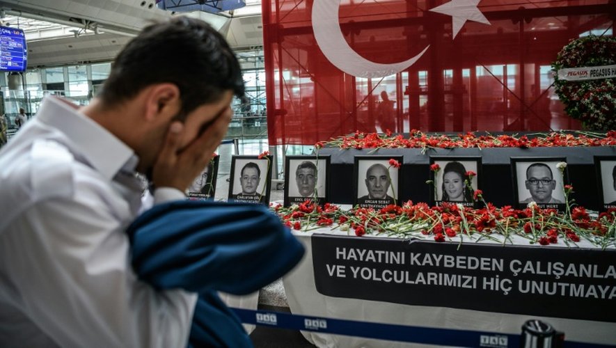 Un employé de l'aéroport se recueille devant un autel en hommage aux victimes des attentats, à l'aéroport Atatürk d'Istanbul