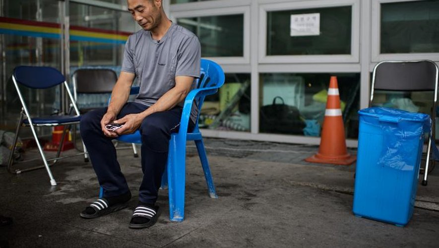 Un homme dont la fille se trouvait à bord du ferry qui a fait naufrage, attend  le 7 juillet 2014 devant le gymnase de Jindo