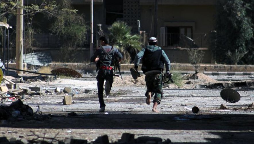 Des rebelles syriens courent dans les rues de Deir Ezzor, le 3 octobre 2013