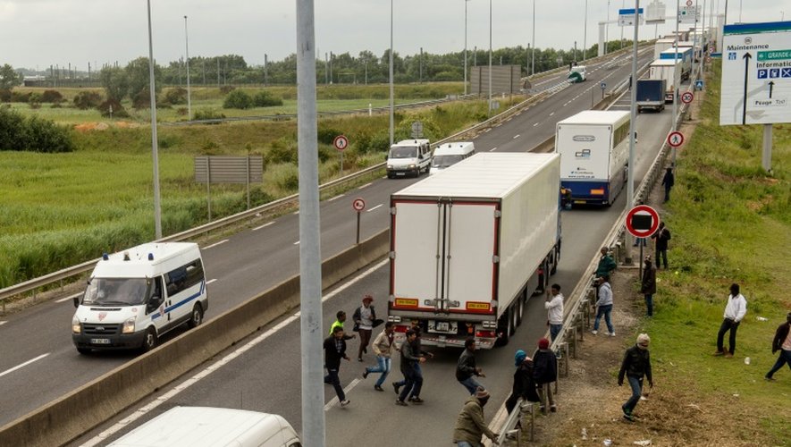 Des migrants tentent de monter dans les camions pour accéder au tunnel sous la Manche et passer en Grande-Bretagne, le 23 juin 2015 à Calais
