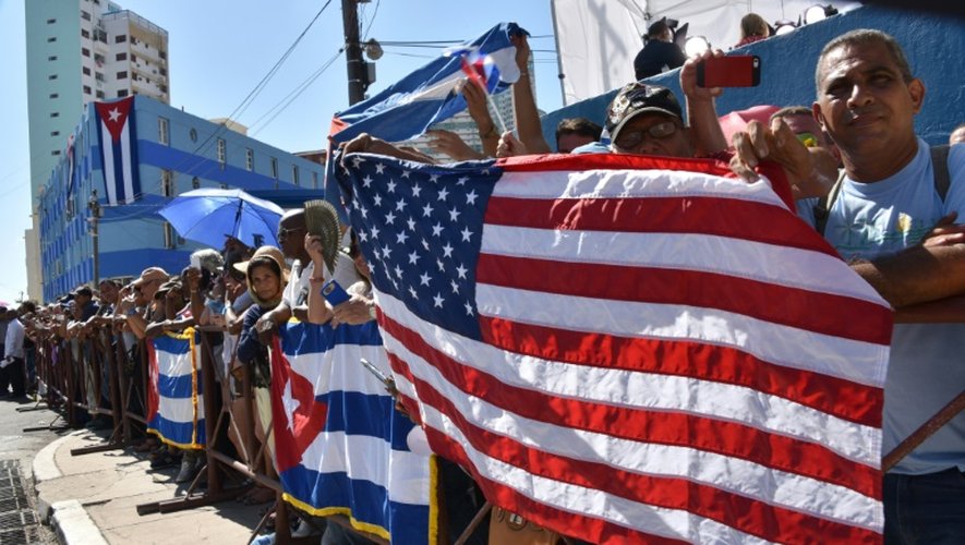 Des cubains, venus assister au discours de John Kerry, déploient les deux drapeaux américain et cubain devant l'ambassade américaine, le 14 août 2015