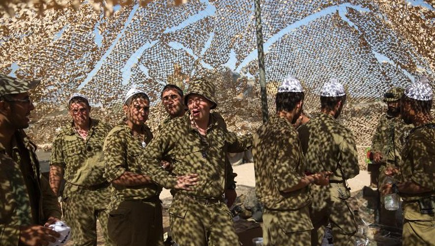 Des soldats israéliens attendent à l'ombre sur la frontière avec la bande de Gaza, le 15 juillet 2014