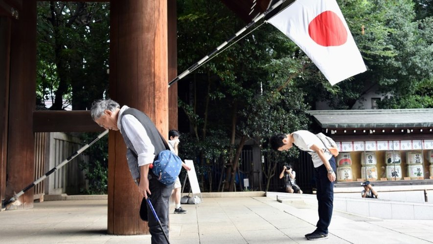 Des Japonais s'inclinent devant l'entrée du sanctuaire Yasukuni à Tokyo le 15 août 2015, dans le cadre des cérémonies marquant la capitulation du pays il y a 70 ans