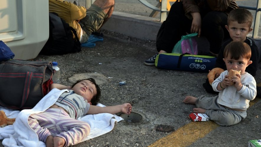 Des enfants dorment sur le sol, le 16 août 2015 au port de Kos après avoir débarqué en provenance de Syrie
