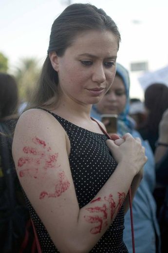 Une femme portant des traces de peintures symbolisant les mains sanglantes d'agresseurs sexuels, lors d'une manifestation au Caire contre les agressions et le harcèlement sexuels au Caire le 14 juin 2014