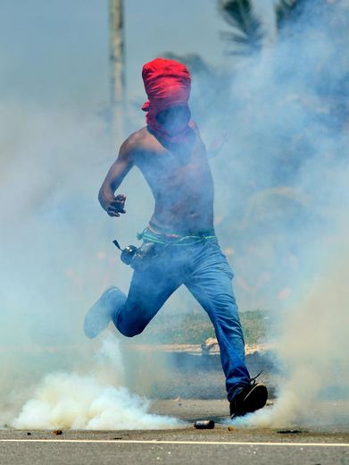 Un manifestant s'apprête à taper dans une cartouche de gaz lacrymogène à Rio de Janeiro, le 21 octobre 2013