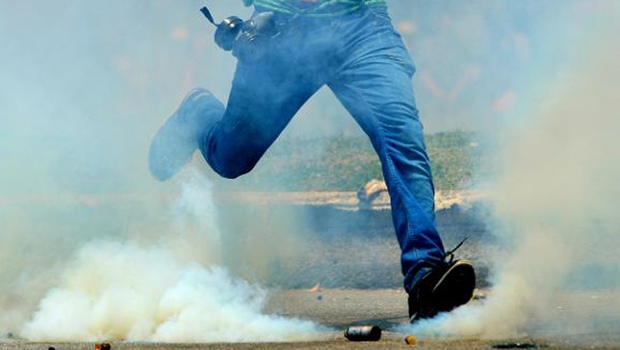 Un manifestant s'apprête à taper dans une cartouche de gaz lacrymogène à Rio de Janeiro, le 21 octobre 2013