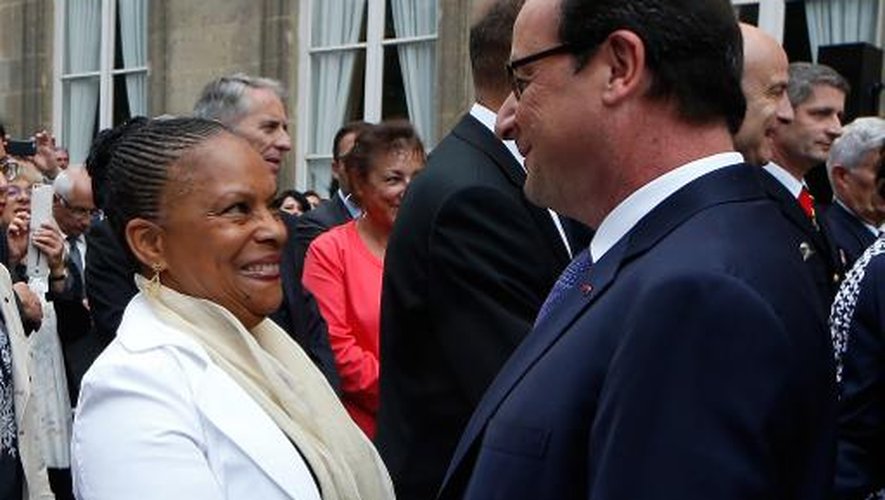 Le président François Hollande salue la ministre de la Justice Christiane Taubira au cours d'une réception en l'honneur des forces armées à l'Hôtel de Brienne, à Paris, le 13 juillet 2014