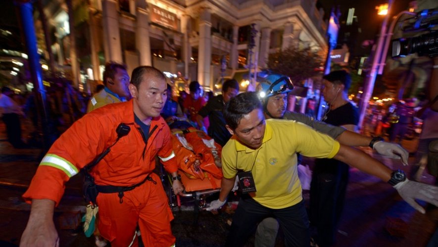 Des sauveteurs portent un blessé après l'explosion d'une bombe à l'extérieur du sanctuaire d'Erawan, situé en plein coeur de la capitale thaïlandaise, le 17 août 2015