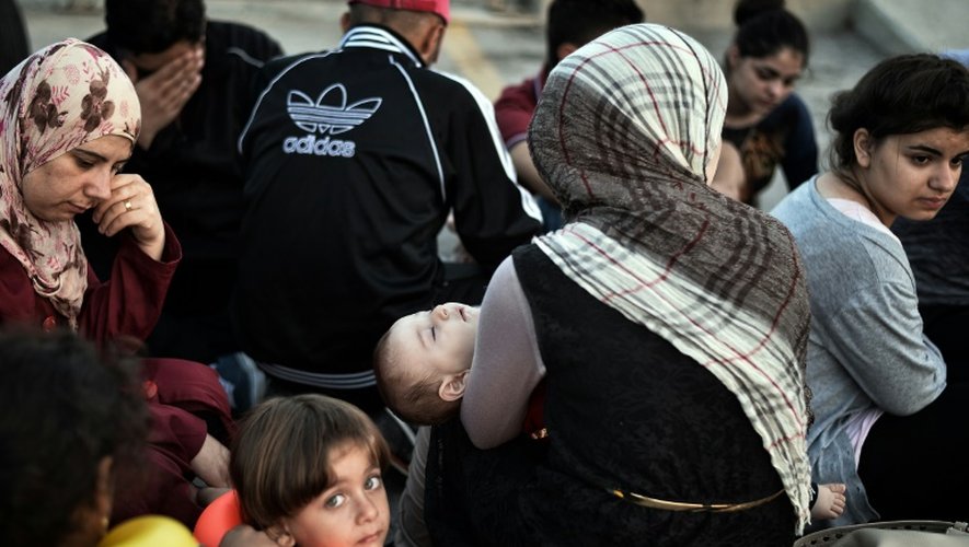 Des migrants syriens attendent d'être enregistrés admin istrativement dans le port de l'île de kjos en Grèce, le 17 août 2015
