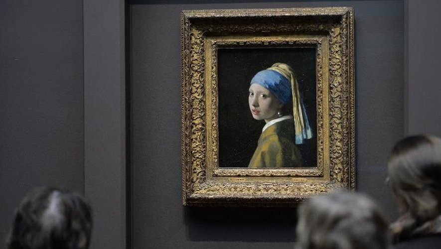 Des visiteurs admirent la "Jeune Fille à la Perle" de Johannes Vermeer, exposée le 21 octobre 2013 à la Frick collection, à New York, dans le cadre de l'exposition "Vermeer, Rembrandt et Hals: chefs d'oeuvre de la peinture hollandaise du Mauri