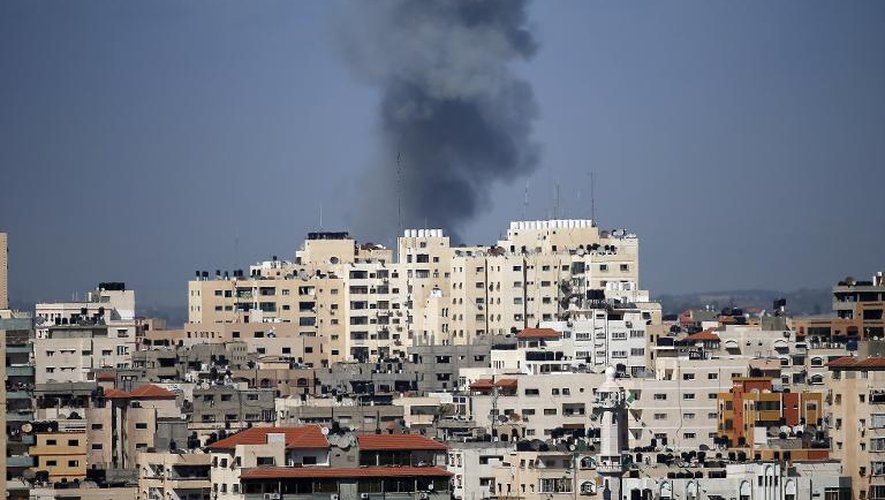 De la fumée s'élève au dessus d'un immeuble touché par une frappe aérienne israélienne à Gaza le 17 juillet 2014