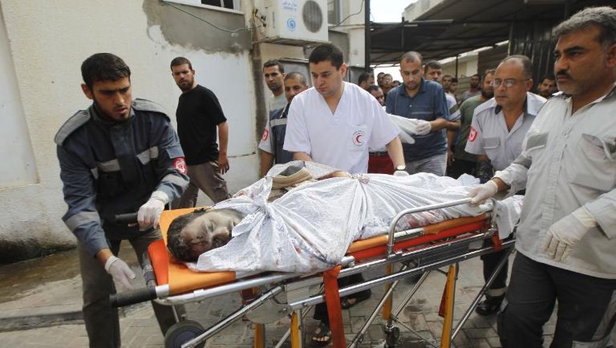 Les secours palestiniens transportent un homme tué par les tirs d'un char israélien quelques minutes avant la trêve, le 17 juillet 2014 à Rafah dans la bande de Gaza