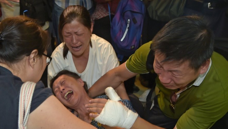 Des proches du touriste chinois, tué lors de l'attentat à la bombe qui a fait 20 morts, pleurent après l'avoir identifié à l'Institut médico-légal de Bangkok, le 18 août 2015