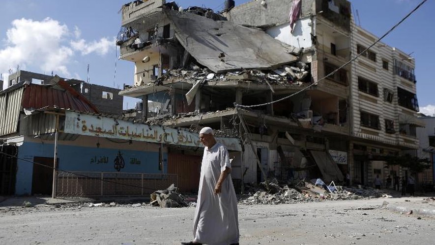 Un vieux Palestinien passe devant un immeuble endommagé par une frappe aérienne israélienne, le 17 juillet 2014 à Gaza