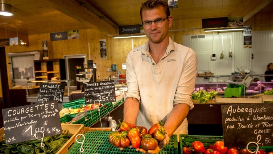 Un agriculteur montre ses tomates dans un magasin de producteurs "Talents de fermes" le 13 août 2015 à Wambrechies, dans le Nord