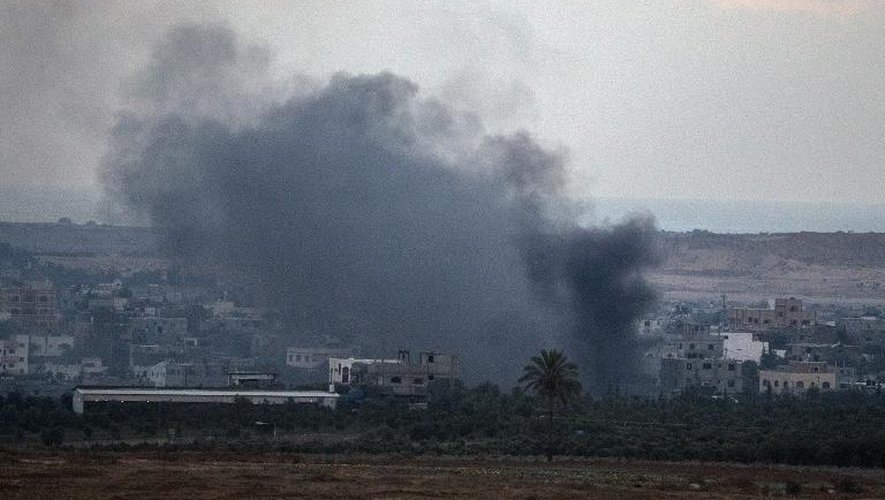 De la fumée s'élève de bâtiments touchés par une frappe aérienne israélienne dans la bande de Gaza le 17 juillet 2014