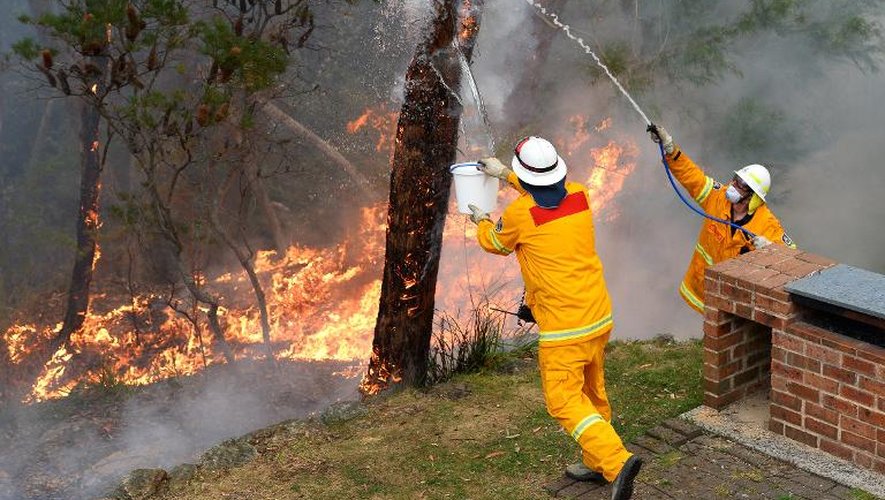 Des pompiers australiens tentent de protéger une maison contre un incendie, le 22 octobre 2013 dans les Montagnes Bleues, près de Sydney