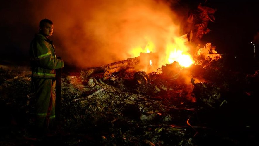Un pompier au milieu des des débris en feu de l'avion malaisien qui s'est écrasé, le 17 juillet 2014 près de Shaktarsk en Ukraine