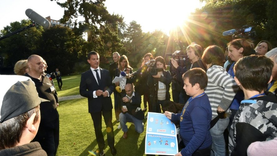 Le Premier ministre Manuel Valls accueille des enfants à Matignon le 19 août 2015, lors d'une journée organisée par le Secours populaire