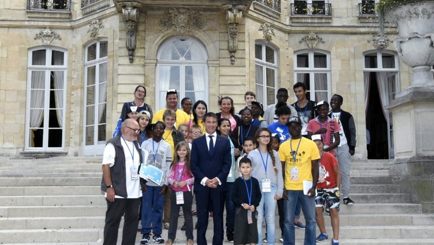 Le Premier ministre Manuel Valls (c) pose avec des enfants à Matignon le 19 août 2015, lors d'une journée spéciale organisée par le Secours populaire