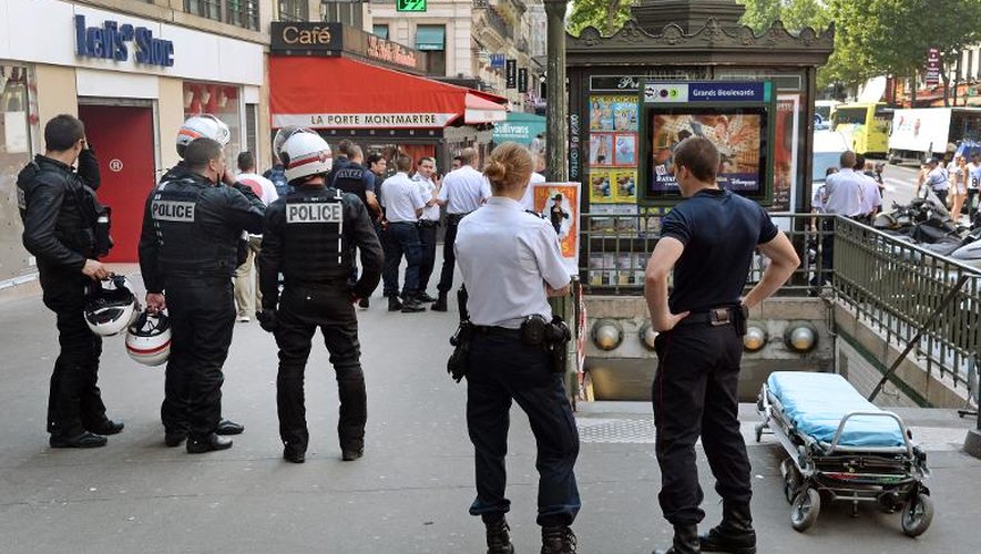 Des officiers de police devant la station de métro Grands Boulevards à Paris, où le suspect d'un braquage raté en fuite s'est engouffré le 19 juillet 2014