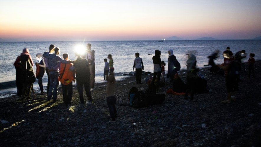 Des migrants se prennent en photo avec leur smartphone après avoir débarqué sur une plage de l'île grecque de Kos, le 12 août 2015