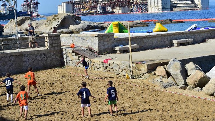 Des enfants jouent au football sur une plage de l'île de Giglio, le 19 juillet 2014