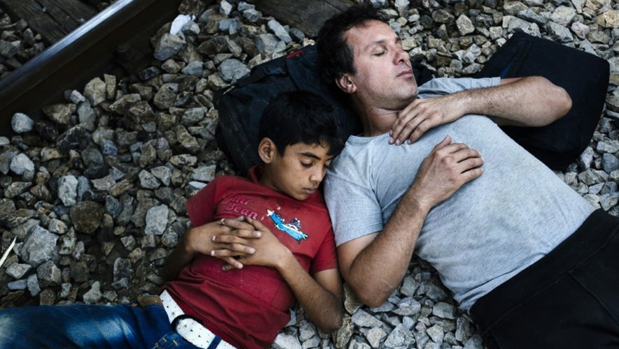 Des migrants se reposent sur les voies de la gare de Gevgelija, à la frontière entre la Macédoine et la Grèce, le 13 août 2015