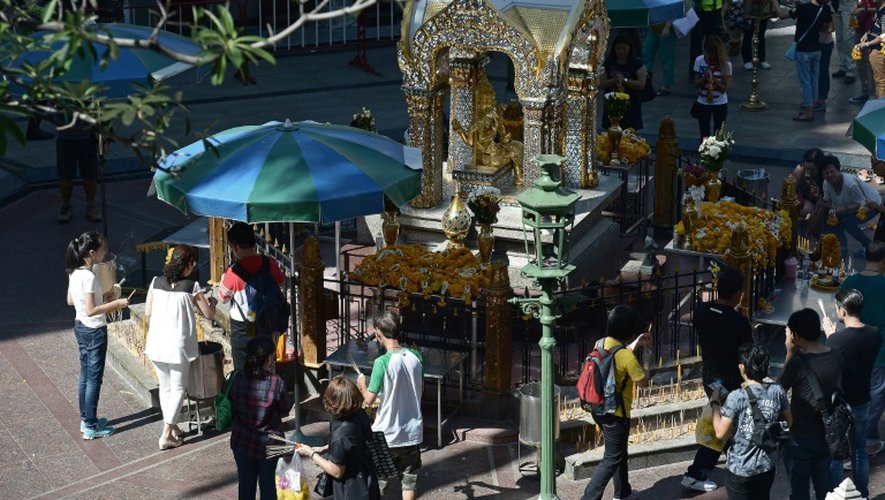 Des habitants prient au temple d'Erawan, le site touristique où 20 personnes ont été tuées le 17 août, le 20 août à Bangkok
