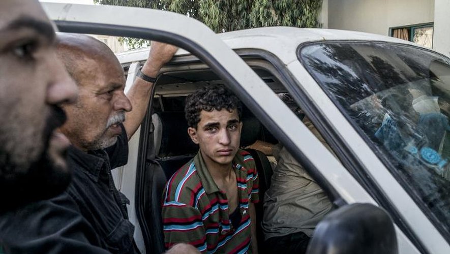 Des Palestiniens dont un proche a été tué dans un pilonnage israélien de Chajaya, en banlieue de Gaza, à la sortie de la morgue de l'hôpital al-Chifa le 20 juillet 2014