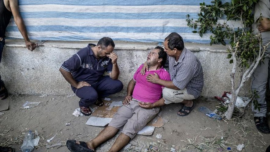 Un Palestinien fait un malaise après avoir récupéré le corps d'un proche à la morgue de l'hôpital al-Chifa, victime d'un pilonnage à Chajaya, en banlieue de Gaza, le 20 juillet 2014