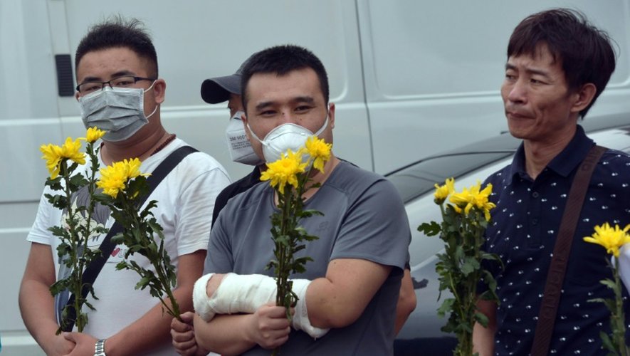 Un blessé se recueille lors d'un hommage aux pompiers et soldats tués dans les explosions de Tianjin, le 18 août 2015