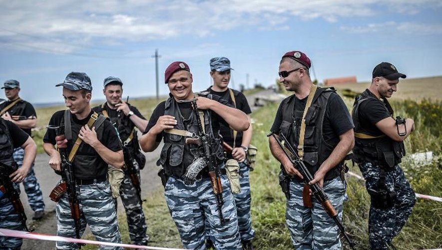 Des séparatistes pro-russes devant les décombre de l'avion malaisien le 20 juillet 2014 près de Grabove dans la région de Donetsk