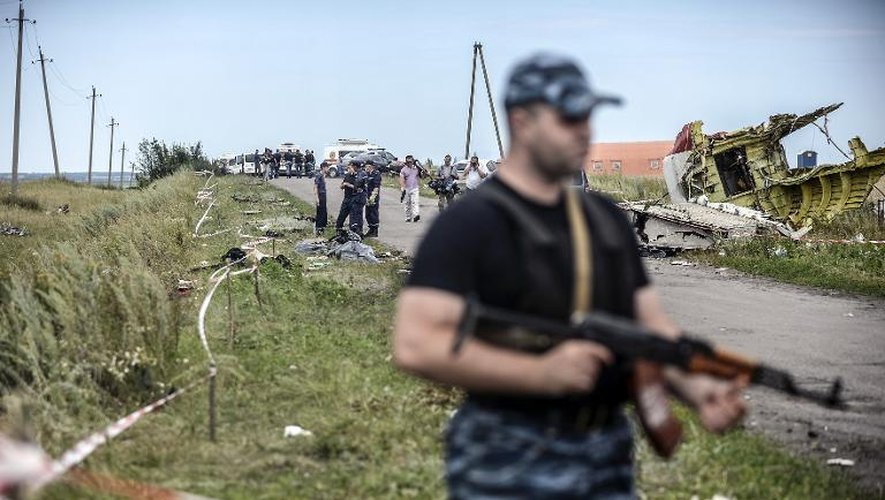 Un séparatiste pro-russe monte la garde devant les décombre de l'avion malaisien le 20 juillet 2014 près de Grabove dans la région de Donetsk