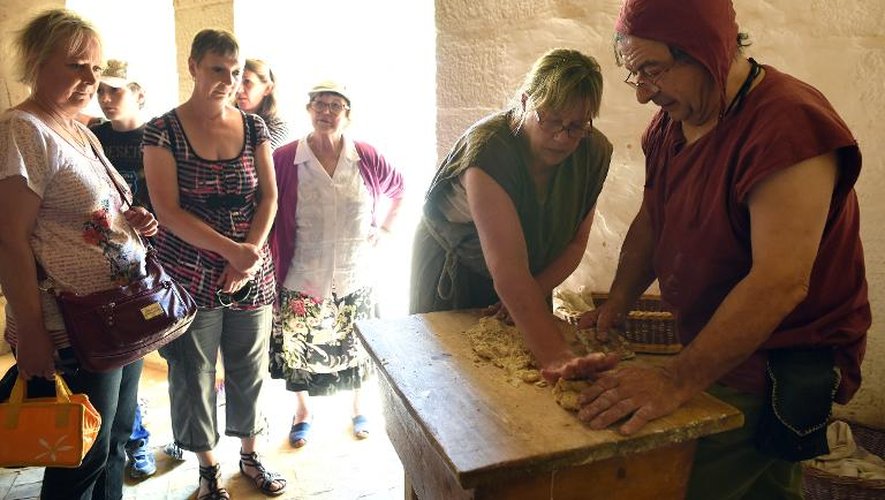Le "talemelier", c'est-à-dire le boulanger, pétrit la pâte à la manière du XIIIe siècle sur le site de Guédelon, dans l'Yonne, le 15 juillet 2014
