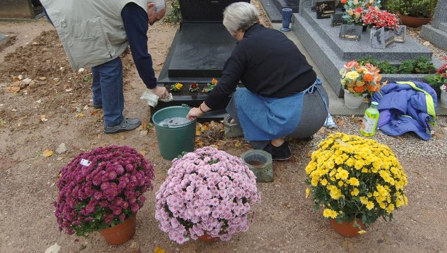 Un couple entretient la tombe d'un proche le 26 octobre 2006 dans un cimetière de Caen